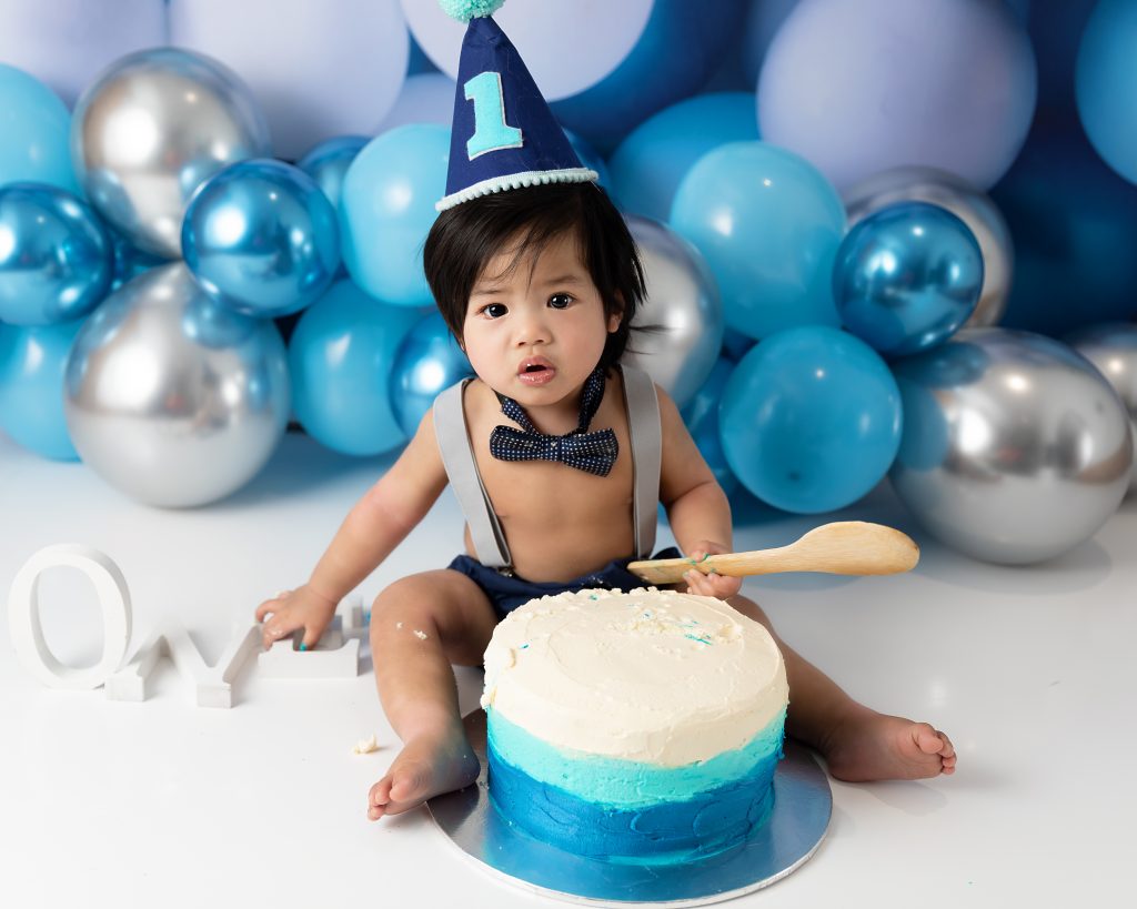 Boy enjoying his 1st birthday cake smash session at Daisy May Photography in County Armagh