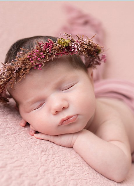 Newborn baby girl in soft pink, wearing a delicate floral halo – Daisy May Photography, newborn photographer in Co. Armagh, Northern Ireland.