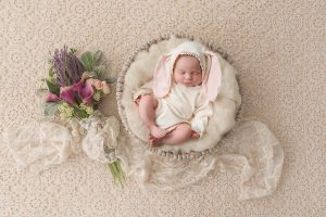 Adorable newborn baby girl dressed in a bunny outfit, nestled in a soft cream nest – Daisy May Photography, newborn photographer in Co. Armagh, Northern Ireland.